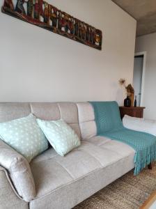 un sofá con almohadas en la sala de estar en Apartamento centrico en Minas