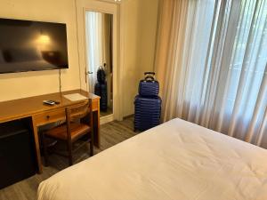 a hotel room with a bed and a desk and a television at Hotel Park Ge.Al. in Città di Castello