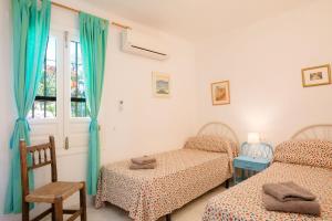 Un dormitorio con dos camas y una ventana. en Casablanca 50 Oasis Properties, en Nerja
