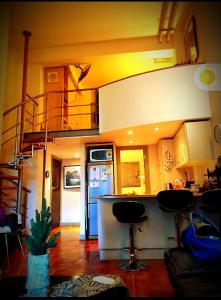 ein Wohnzimmer mit einer Küche und einer Wendeltreppe in der Unterkunft Studio loft in the heart of Cape Town in Kapstadt
