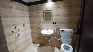 a bathroom with a toilet and a sink at Bequest Stays In Puri in Puri