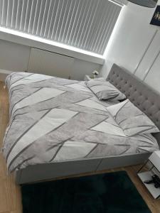 a bed in a bedroom with a white bedspread at Cosy 2 Bedroom Apartment in South West London in London