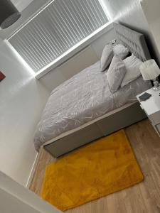 a bed in a small room with a floor at Cosy 2 Bedroom Apartment in South West London in London