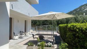 a patio with a table and an umbrella at Appartamenti Nataly in Nago-Torbole