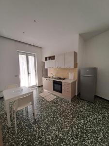 Family home في أندريا: مطبخ فارغ مع طاولة وثلاجة
