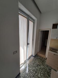 Family home في أندريا: غرفه فاضيه فيها نافذتين وباب