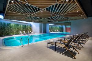 a swimming pool with a row of chairs around it at Hilton Garden Inn Istanbul Beylikduzu in Istanbul