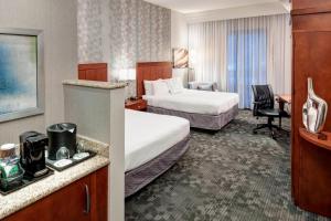 a hotel room with two beds and a desk at Courtyard by Marriott Franklin Cool Springs in Franklin