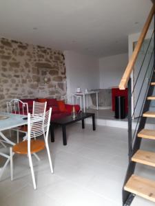 a living room with a table and chairs and a couch at Creusoé in Saint-Marc-à-Frongier