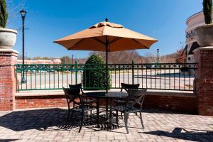 a table and chairs with an umbrella in front of a fence at Courtyard by Marriott Franklin Cool Springs in Franklin