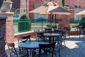 un patio con tavoli, sedie e ombrellone di Courtyard by Marriott Franklin Cool Springs a Franklin