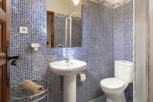 Un baño con azulejos azules, inodoro y lavabo. en Casablanca 38 Oasis Properties, en Nerja 32 fotos más