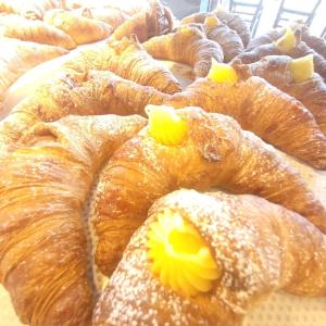un mucchio di croissant seduti su un tavolo di Alloggio turistico a casa di Paoletto a Fiumicino