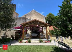 a gazebo with chairs and tables in a yard at Casas da Biquinha in Sintra