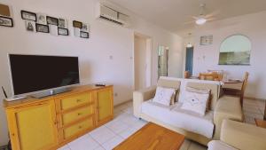 a living room with a television on a wooden dresser at STAY Tala Sea View Apartment in Tala