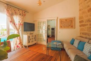 ein Wohnzimmer mit einem Sofa und einem TV in der Unterkunft Pool House “El Estanco 14” in Vega de San Mateo