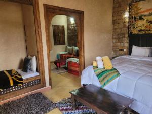 1 dormitorio con cama, mesa y espejo en Chambre d'hôtes aya en Ouzoud