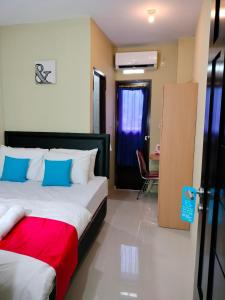 Maluku Residence Syariah في امبون: غرفة نوم بسرير ومكتب وكرسي