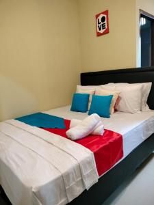 two beds with colorful sheets and pillows in a bedroom at Maluku Residence Syariah in Ambon