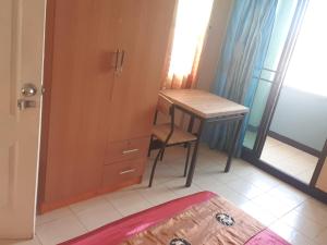 a bedroom with a desk and a table with a chair at Roong-Arun Apartment in Bangkok