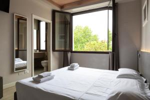 a bedroom with a large white bed and a window at Plus Florence in Florence
