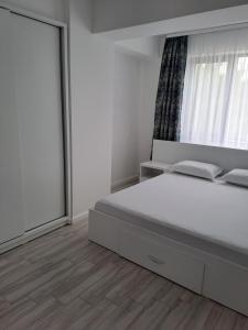 biała sypialnia z łóżkiem i oknem w obiekcie Come&Chill w Krajowej