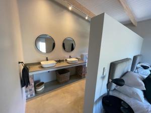uma casa de banho com dois lavatórios e dois espelhos em Windon vineyard farmhouse em Stellenbosch