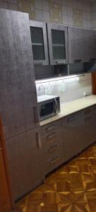 una cocina con encimera y microondas en Yunusabad apartment 19, 1, en Magaldarkhan