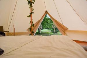 a bed in a tent with a window at Glamping Bolmen, Seaview, free canoe in Odensjö
