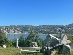 a bench on a hill with a view of a lake at APARTMENTS EDWINA in Portorož