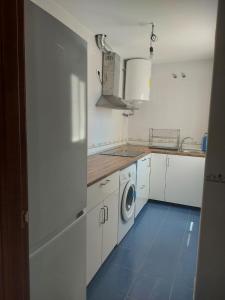 a kitchen with white cabinets and a washing machine at El Mirador in Prado del Rey