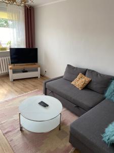 a living room with a couch and a coffee table at Mieszkanie w centrum Giżycka in Giżycko