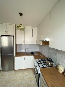 a kitchen with white cabinets and a stove top oven at Mieszkanie w centrum Giżycka in Giżycko +9 photos