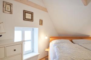 a bedroom with a bed and a window at Reetdachhaus Haubarg-Kieker in Simonsberg