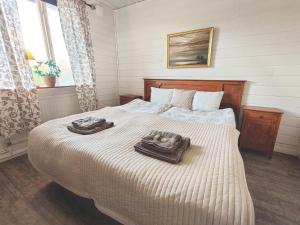 1 dormitorio con 1 cama con 2 toallas en Långforsen Glamping & Lapland Experience, 