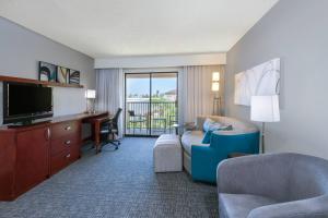 a living room with a couch and a television and a desk at Courtyard Harlingen in Harlingen