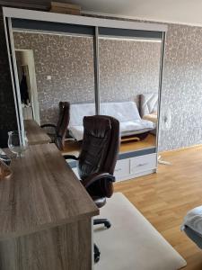 een kamer met een bureau, stoelen en een bed bij Vienības in Krāslava