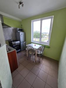 a kitchen with a table and chairs and a window at Vienības in Krāslava