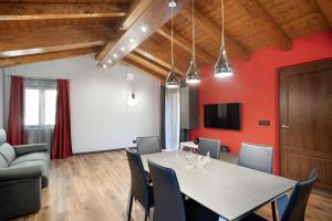 una sala da pranzo con pareti rosse e tavolo e sedie di Agriturismo il Borgo - Rosmarino a Villanova dʼAlbenga