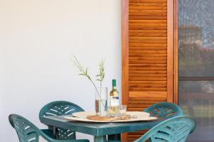a table with a bottle of wine and chairs at ISA-Apartments with air conditioning and external outdoor space in Budoni, at only 300 m from the beach in Budoni