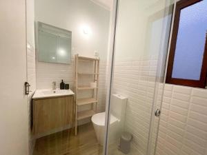 La salle de bains blanche est pourvue de toilettes et d'un lavabo. dans l'établissement green guest house. Figueira da Foz, à Figueira da Foz