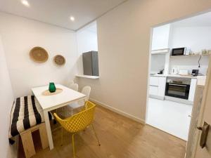 a small dining room with a table and a kitchen at green guest house. Figueira da Foz in Figueira da Foz