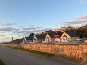 una fila de casas junto a una pared de piedra en Dolphin View Cottages en Portmahomack