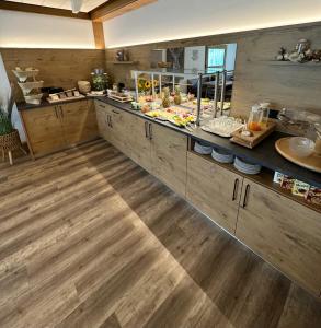 a kitchen with wooden floors and a counter with food at Gästehaus Gaiser in Baiersbronn