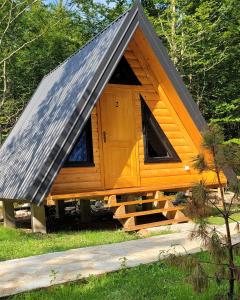 uma pequena cabina de madeira com um telhado inclinado em WildBeauty Grebaje em Vusanje