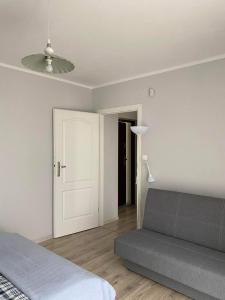 a bedroom with a bed and a lamp and a door at Willa Relaksowa in Karwia