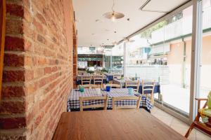 ein leeres Restaurant mit Tischen und Stühlen und einer Backsteinmauer in der Unterkunft Residence Burano in Lido di Jesolo