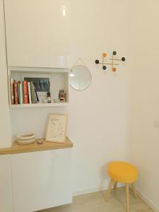 une chambre avec une chaise et une étagère avec des livres dans l'établissement Da Rosa e Pier - Charming central apartment, à Milan
