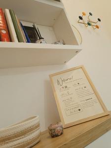un estante con un cartel en una mesa con libros en Da Rosa e Pier - Charming central apartment, en Milán