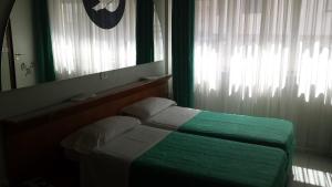 a bedroom with a green bed and a mirror at Grande Albergo Abruzzo in Chieti